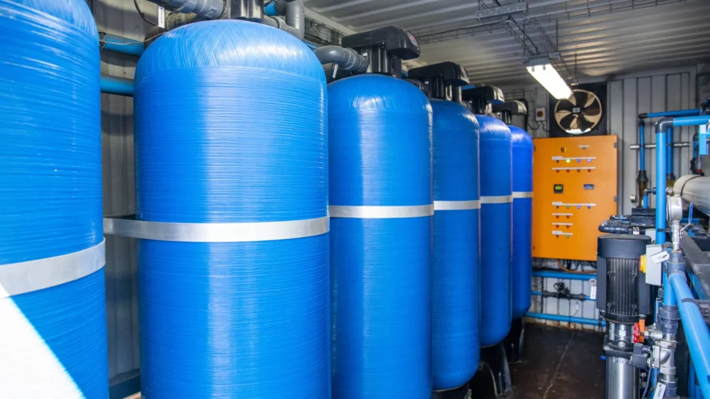Containerized Water Treatment Plant With Blue Tanks And Piping, Providing A Reliable Water Source For Pet Food Production.