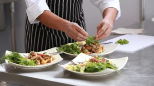 Chef Garnishing Gourmet Dishes In A Professional Kitchen, Symbolizing The Impact Of High-Quality Water On Food And Beverage Perfection.