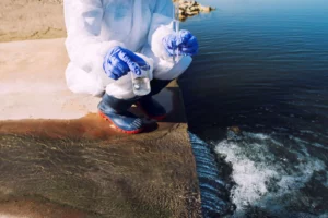 Crouched Ecologist Wearing Gloves And Testing Water Purified Using Water Treatment Equipment