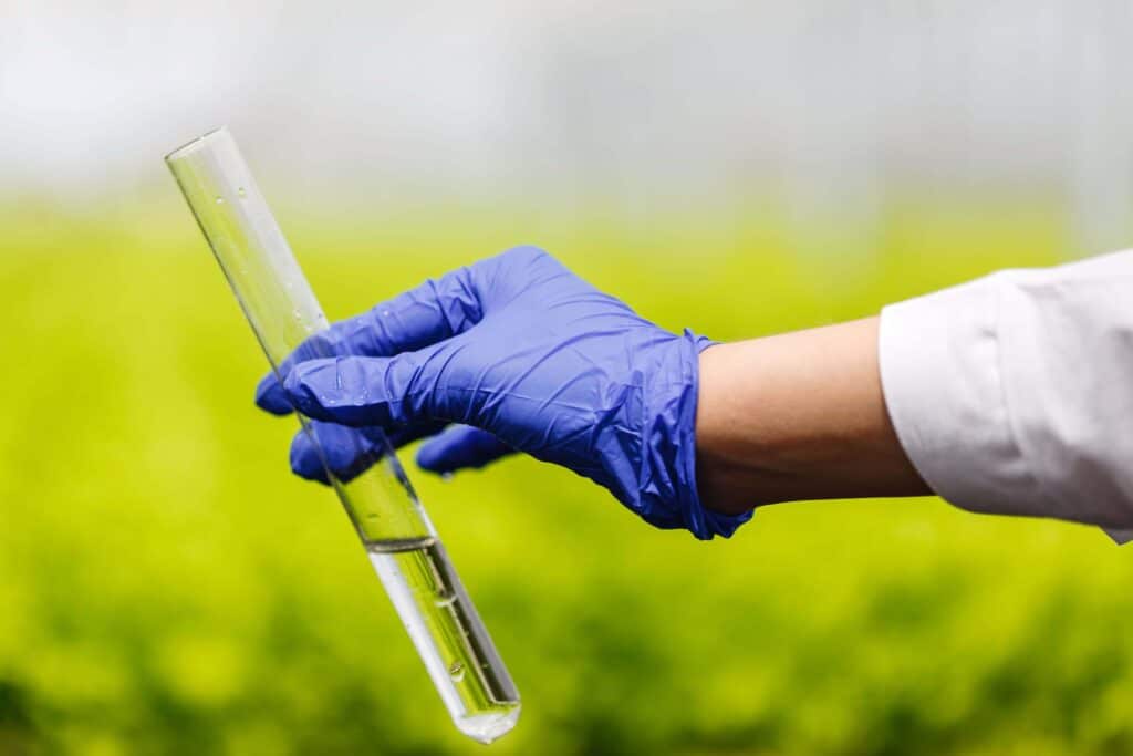 Engineer Viewing A Test Tube Of Clear Water Under Guidance Of Water Treatment Facility Management