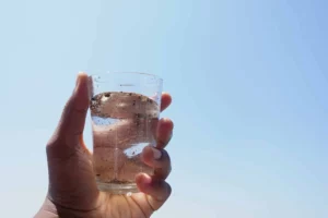 A Person Holding A Glass Of Dirty Water, Symbolising The Importance Of Water Reclamation Efforts.